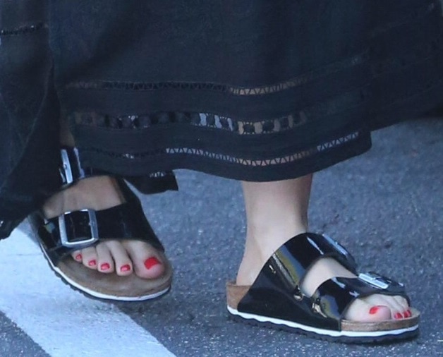 Mena Suvari adds a trendy twist to her ensemble with chunky leather slides