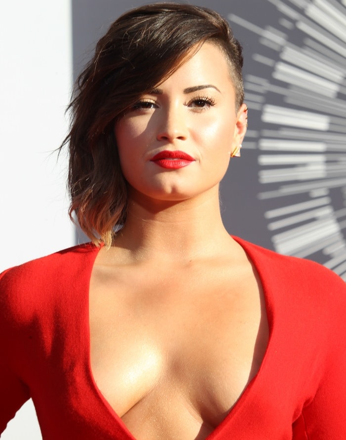 Demi Lovato styled her hair in a dramatic, edgy side-swept look to complement her bold red Lanvin gown at the 2014 MTV VMAs