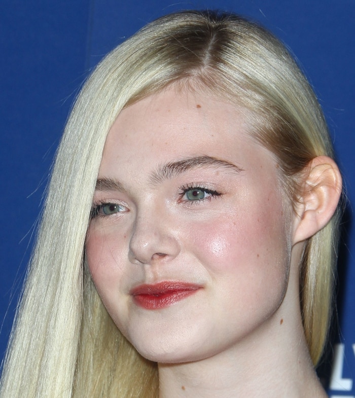 Elle Fanning with natural makeup featuring soft blush and red lipstick
