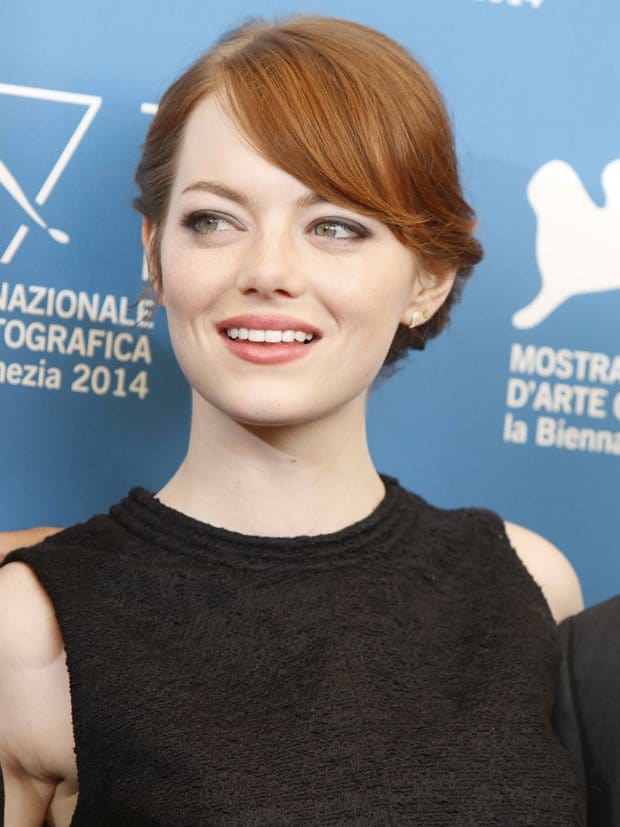 Emma Stone's elegant updo highlights her rich auburn hair color, perfectly complementing her classic and refined look at the 2014 Venice Film Festival