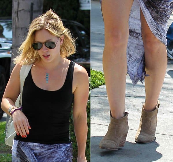 Hilary Duff wearing a printed asymmetrical wrap skirt featuring a batik-inspired pattern with shades of blue and gray, draped to create a high slit that adds a dynamic and flowy element to her outfit