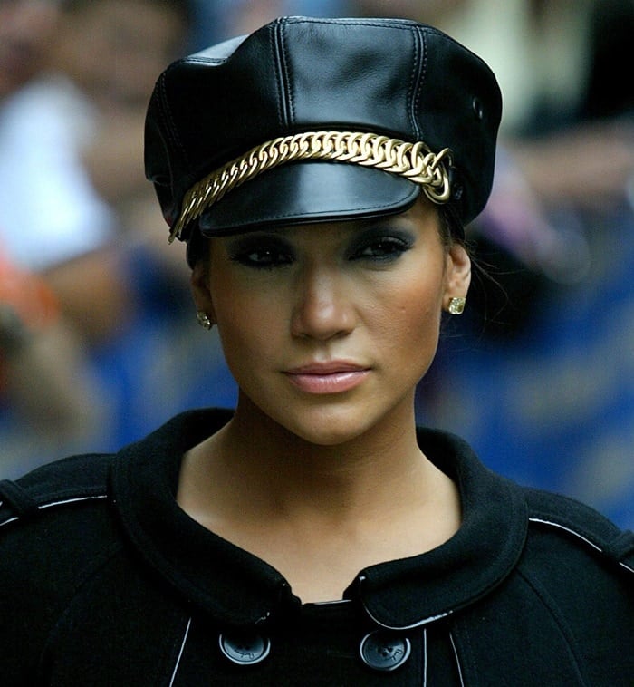 Jennifer Lopez adds a bold edge to her look with an S&M-inspired black leather cap featuring a striking gold chain detail