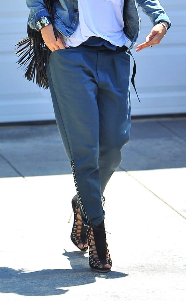 Jennifer Lopez's slouchy pants feature a black leather belt that emphasizes the flattering, folded high-rise waist