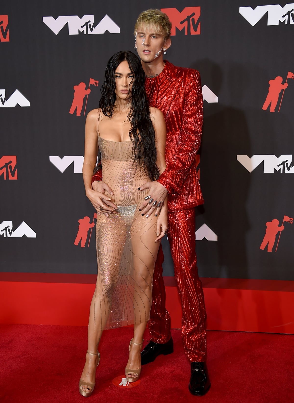 Megan Fox leaving little to the imagination in a see-through Mugler dress and Machine Gun Kelly in a bold red Dolce & Gabbana suit