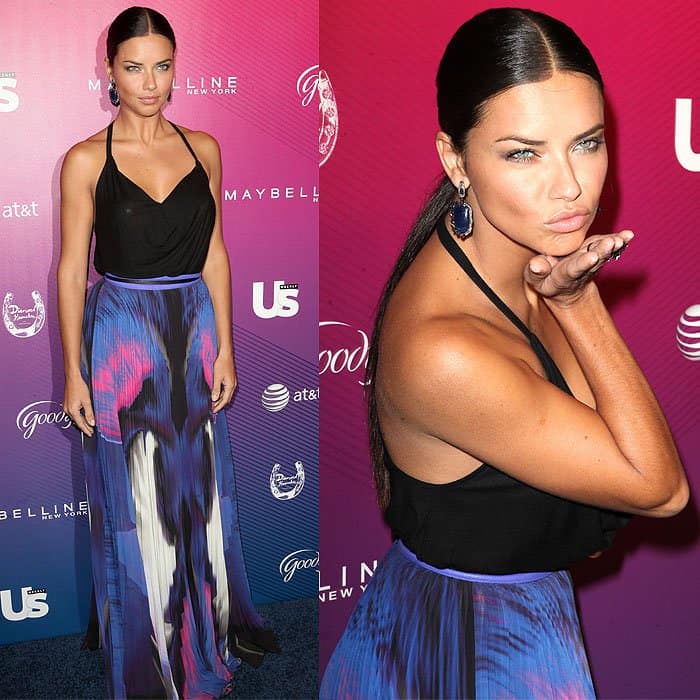 Adriana Lima stuns in a colorful maxi skirt and black halter top, blowing a kiss
