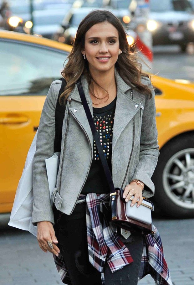 Jessica Alba wearing a plaid shirt tied around her waist and carrying a Mary Katrantzou shoulder bag