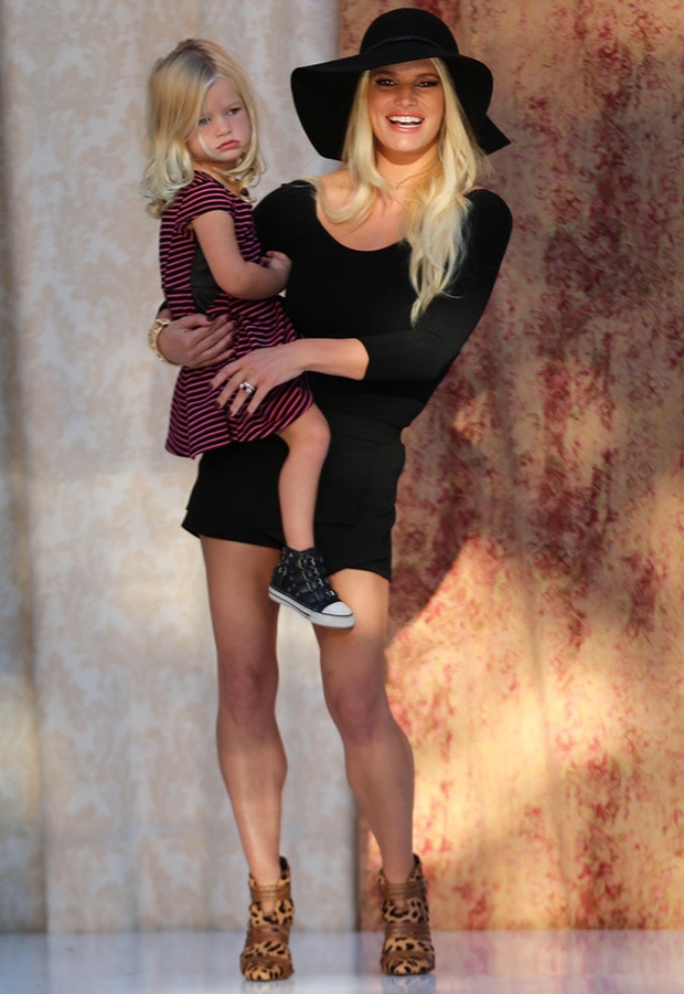 Jessica Simpson radiates effortless style in a chic black ensemble and leopard-print booties, carrying her daughter Maxwell in a sweet mommy-and-me moment at the Nordstrom fashion show