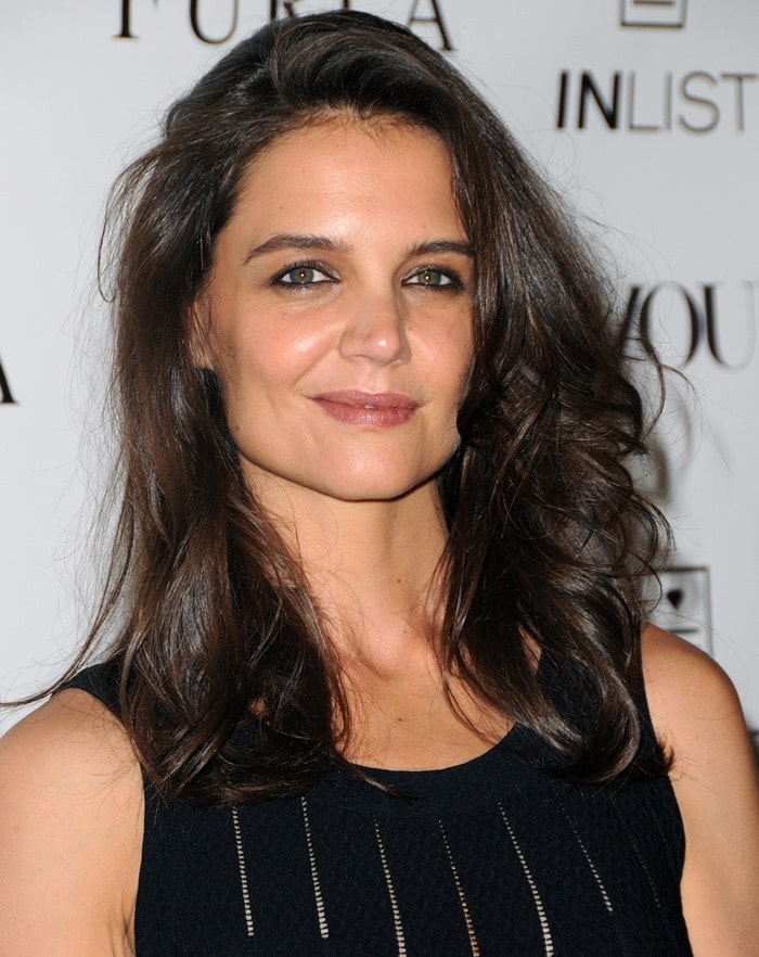 Katie Holmes in a black stretch-knit dress by Azzedine Alaïa featuring ladder-effect vertical stripes