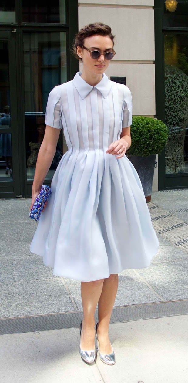 Keira Knightley wears an ethereal pleated Prada dress with a classic collar, effortlessly paired with gleaming silver metallic pumps for a modern retro twist