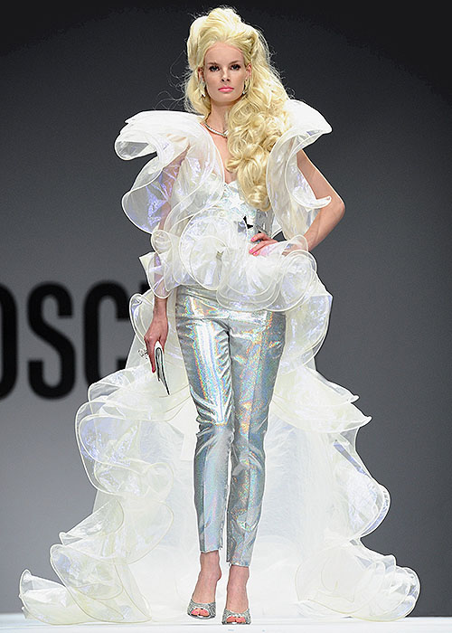 A model dazzles in a shimmering, iridescent outfit with dramatic ruffles and holographic pants from Moschino's Spring 2015 Barbie-inspired collection