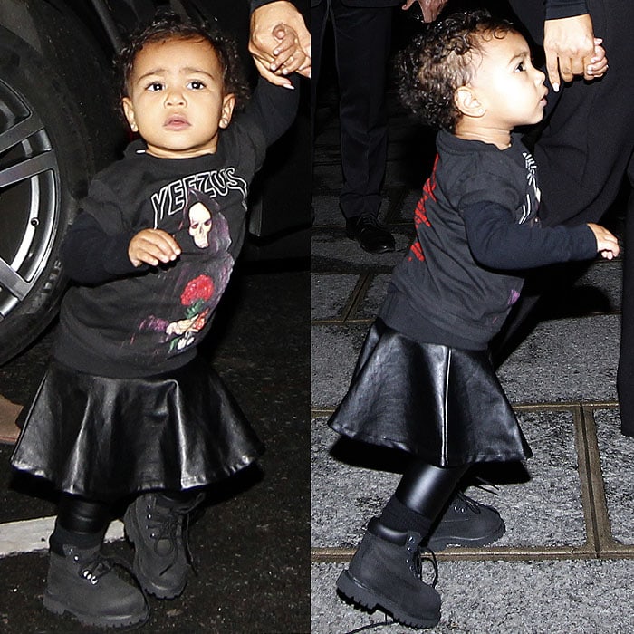 Baby North West in a Yeezus tour sweatshirt, a black leather skirt, black leather leggings, and black Timberland boots