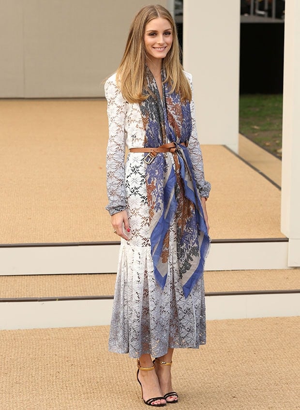 Olivia Palermo stuns at London Fashion Week in a white lace dress, accessorized with a multicolored printed scarf, brown leather belt, and Schutz "Celina" sandals