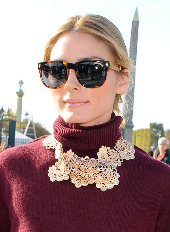 Olivia Palermo wears a gold statement necklace with a Nina Ricci linen and cashmere turtleneck in Bordeaux foncé
