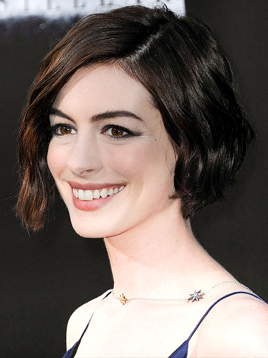 Anne Hathaway's radiant smile and chic wavy bob steal the spotlight at the Interstellar premiere, complemented by a delicate star-themed necklace