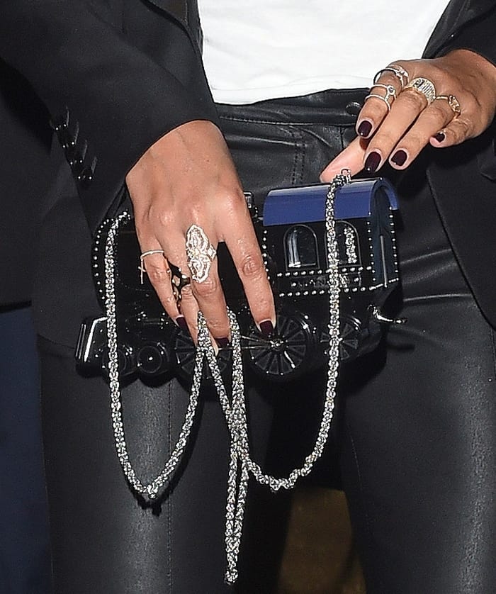 Beyoncé makes a playful statement with her train-shaped purse by Moynat Paris x Pharrell Williams, featuring luxe detailing and a sparkling chain strap