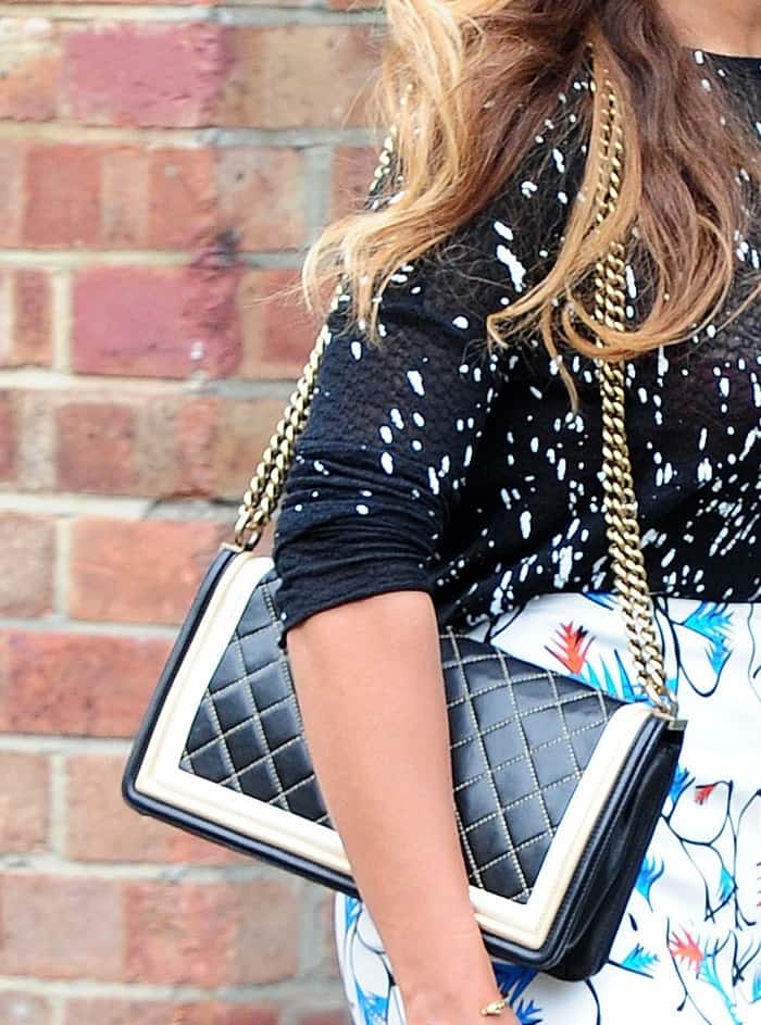 Beyoncé elevates her look with a chic Chanel Boy bag, featuring diamond-quilted leather, bold contrast trim, and a signature gold chain strap
