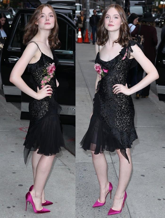 Elle Fanning stuns in a black cami slip dress adorned with floral appliques and vibrant fuchsia pumps at the Letterman Show