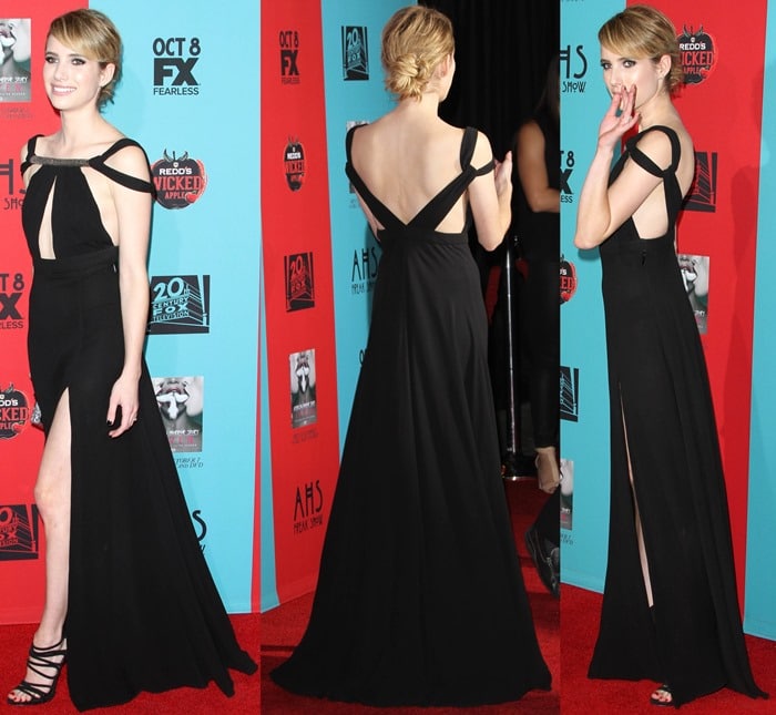 Emma Roberts flaunts her legs in a black gown featuring cutout details, a thigh-high slit, and an embellished neckline