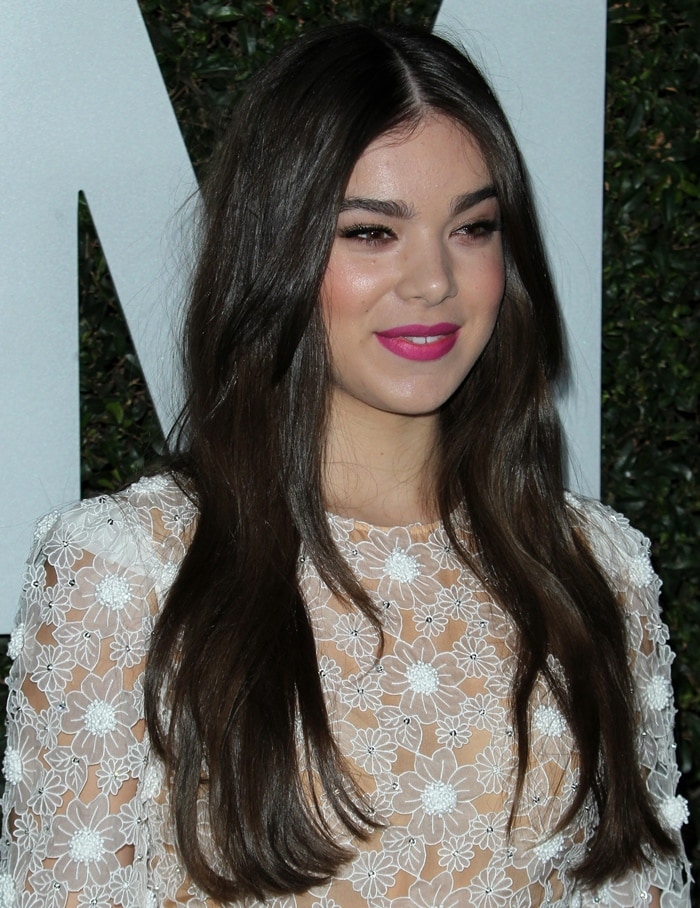 Hailee wearing an embroidered white dress from Michael Kors with long sleeves and round buttons