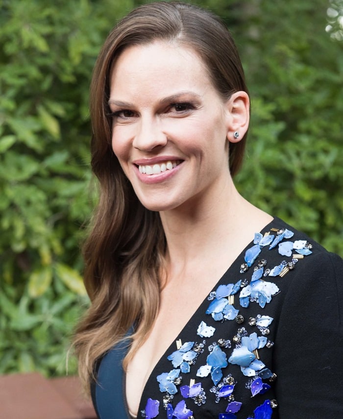 Hilary Swank's dress featured a blue color-block design in a fitted silhouette, embellished with vivid gemstones that added a high-impact visual appeal