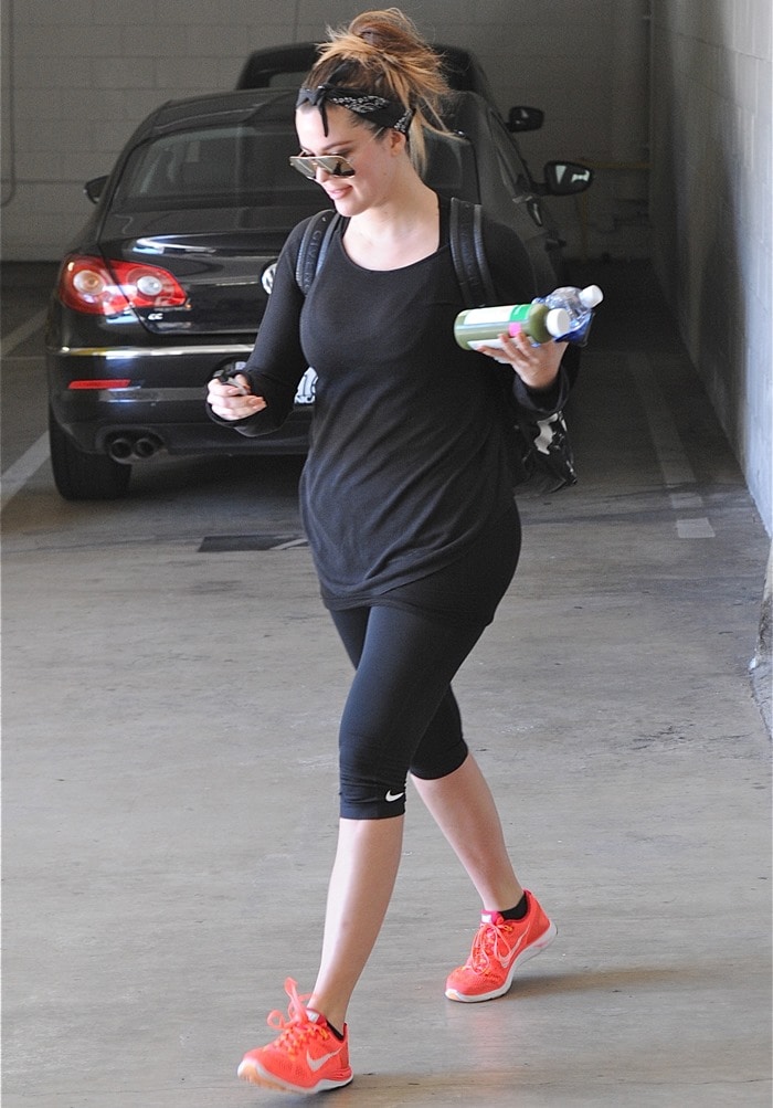 Khloé Kardashian leaving the gym in cropped black leggings and bright orange sneakers