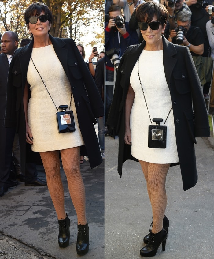 Kris Jenner in a glamorous white mini dress styled with a black wool coat and nude fishnet tights