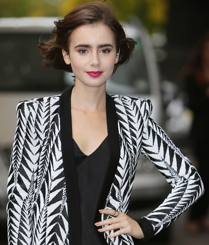 Lily Collins stuns with her bold lip color and stylish Balmain jacket outside ITV Studios