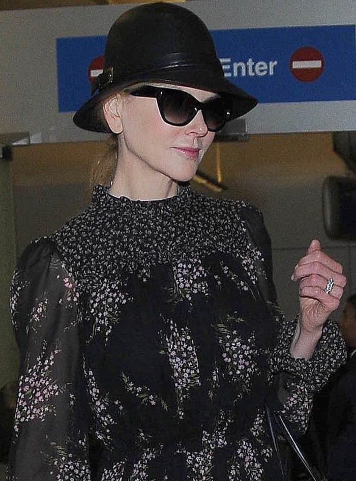 Nicole Kidman arriving at LAX Airport in a floral Michael Kors dress, black leather hat, and sunglasses on October 3, 2014