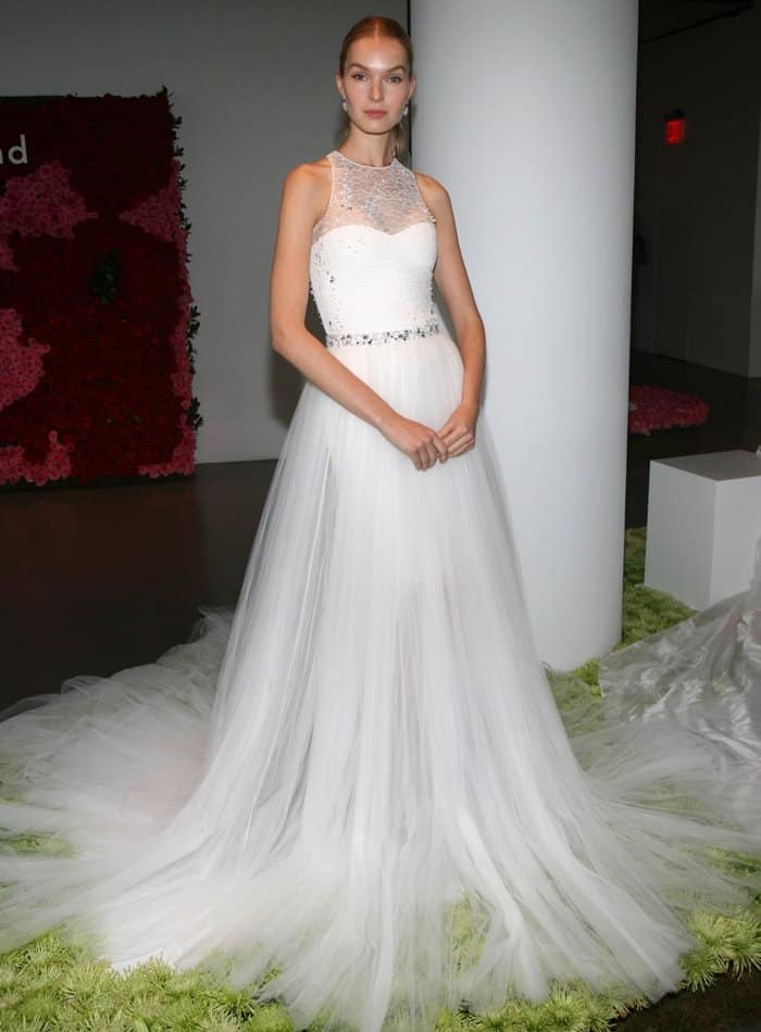 Pamella Roland's bridal collection showcases a stunning gown with a beaded bodice, high neckline, and a flowing tulle skirt, perfect for an elegant bride