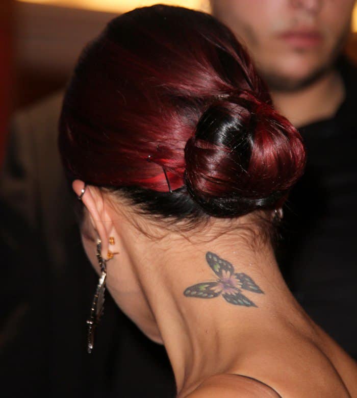 Vanessa Hudgens flaunts her delicate butterfly neck tattoo, featuring soft blue, green, and purple hues, at the Gimme Shelter premiere in Paris