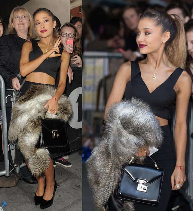Ariana Grande stuns in a black crop top and pencil skirt, accented with a luxurious fur scarf and elegant black handbag