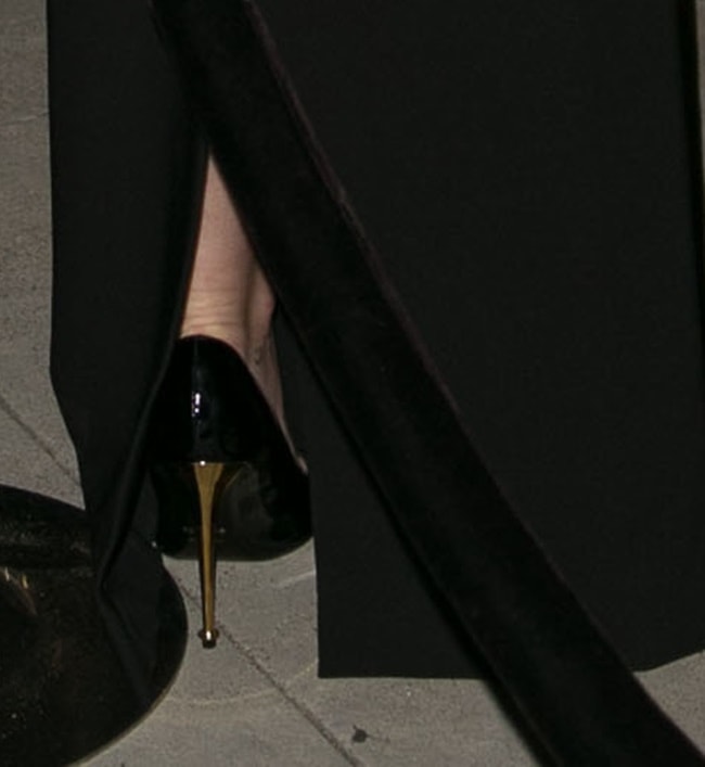 Miley Cyrus wearing simple black pumps detailed with gold heels