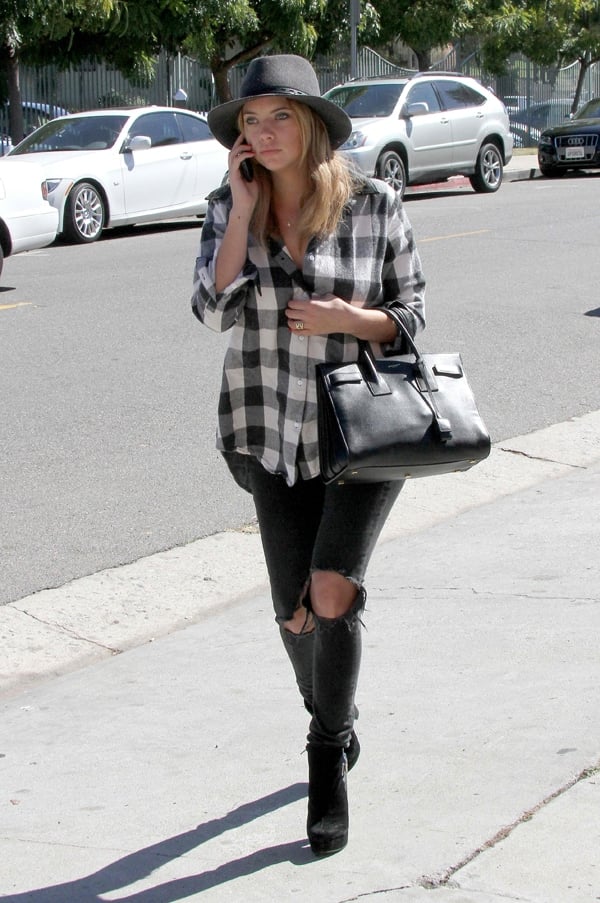 Ashley Benson wearing a gingham plaid top with ripped jeans