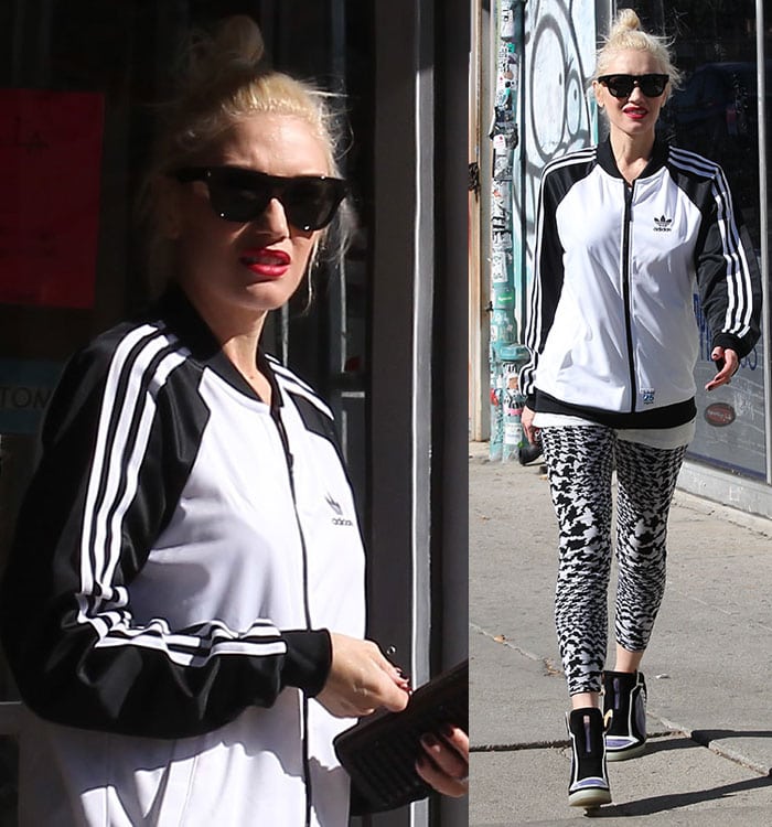 Gwen Stefani wears her platinum blonde hair in a high messy bun and accessorizes with bold red lipstick, oversized black sunglasses, and a sleek black clutch for a sporty-chic street look