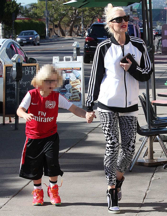 Gwen Stefani steps out with her son in matching sporty-chic style, pairing houndstooth leggings and wedge sneakers with an Adidas track jacket while he shows off vibrant new kicks and an Arsenal soccer jersey