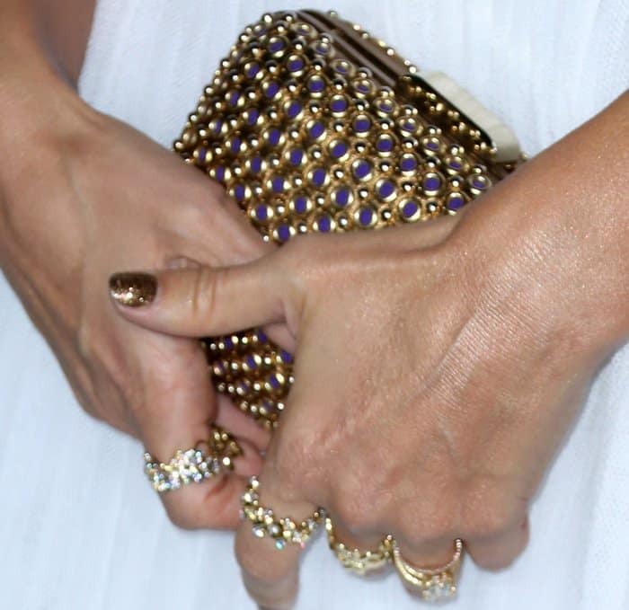 Jessica Alba's ensemble is perfectly accessorized with a dazzling Brian Atwood clutch and sparkling gold rings, completing her sophisticated look
