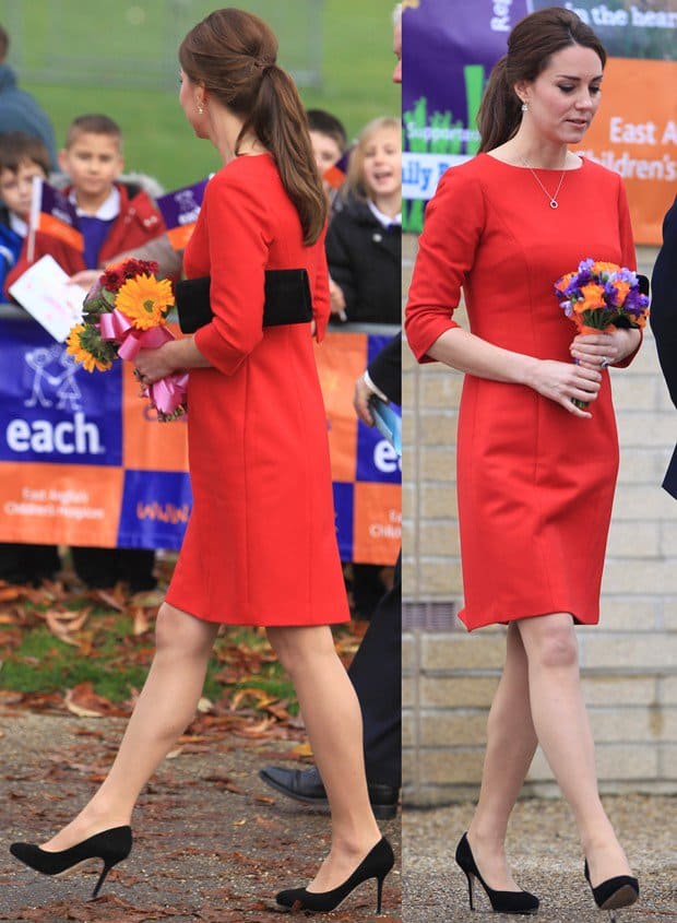 Kate Middleton looks elegant in a classic red dress with three-quarter sleeves, accessorized with a simple necklace and holding a bouquet of flowers