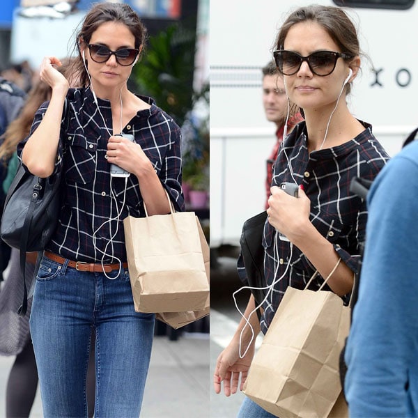 Katie Holmes with earphones plugged tightly into her ears