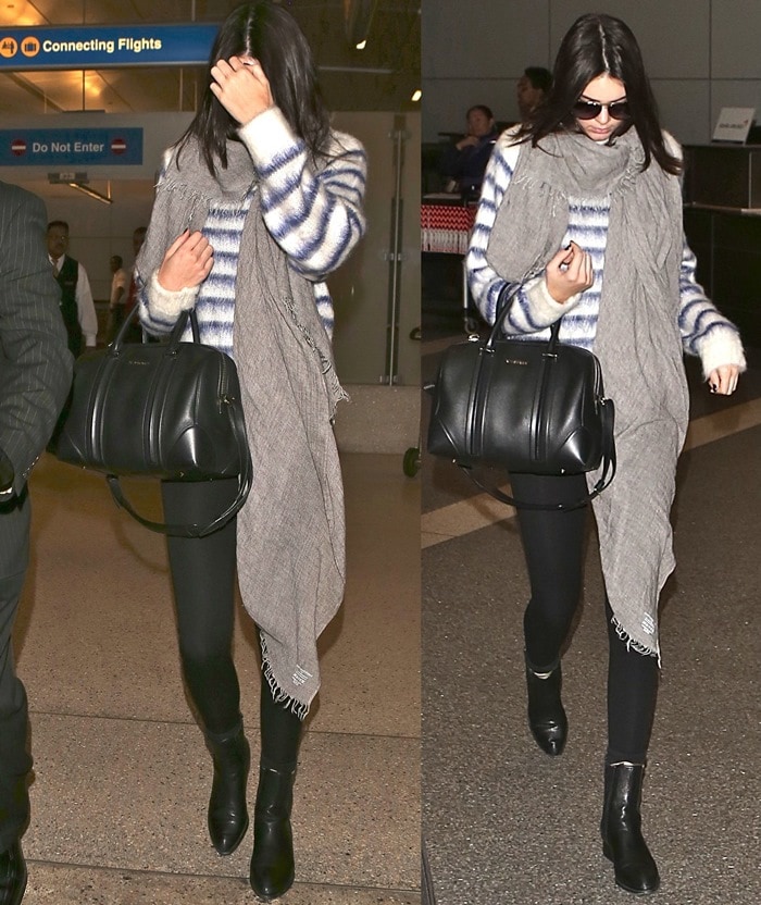 Kendall Jenner, battling acne, pairs Alexander Wang boots with black leggings, a striped mohair H&M sweater, a gray scarf, and a Givenchy duffel at LAX