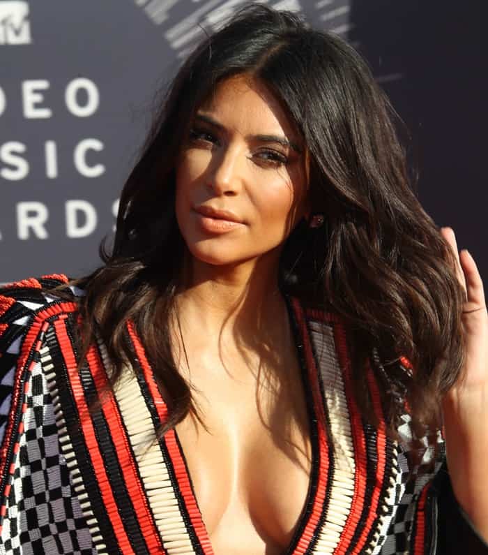 Kim Kardashian showcased a glamorous look with voluminous waves and natural makeup, perfectly complementing her plunging red and black Balmain mini dress