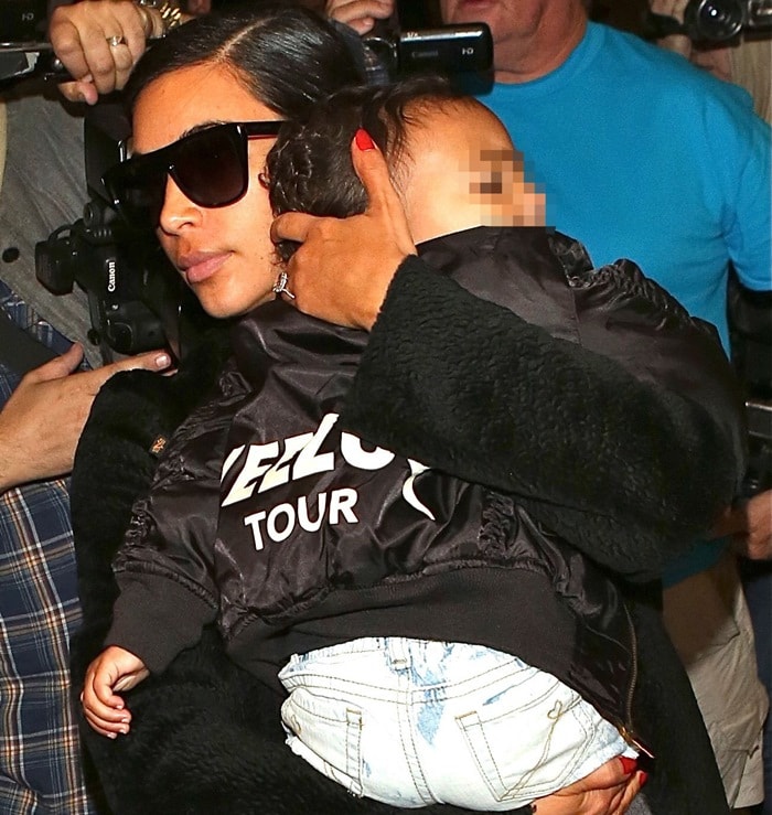 Kim Kardashian carrying her daughter, North West, as she arrives at Los Angeles International Airport (LAX) on November 5, 2014