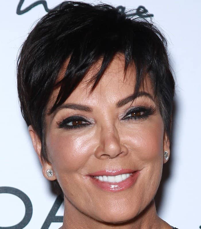Kris Jenner flaunts her chic pixie cut and flawless makeup, featuring bold eyeliner and glossy pink lips