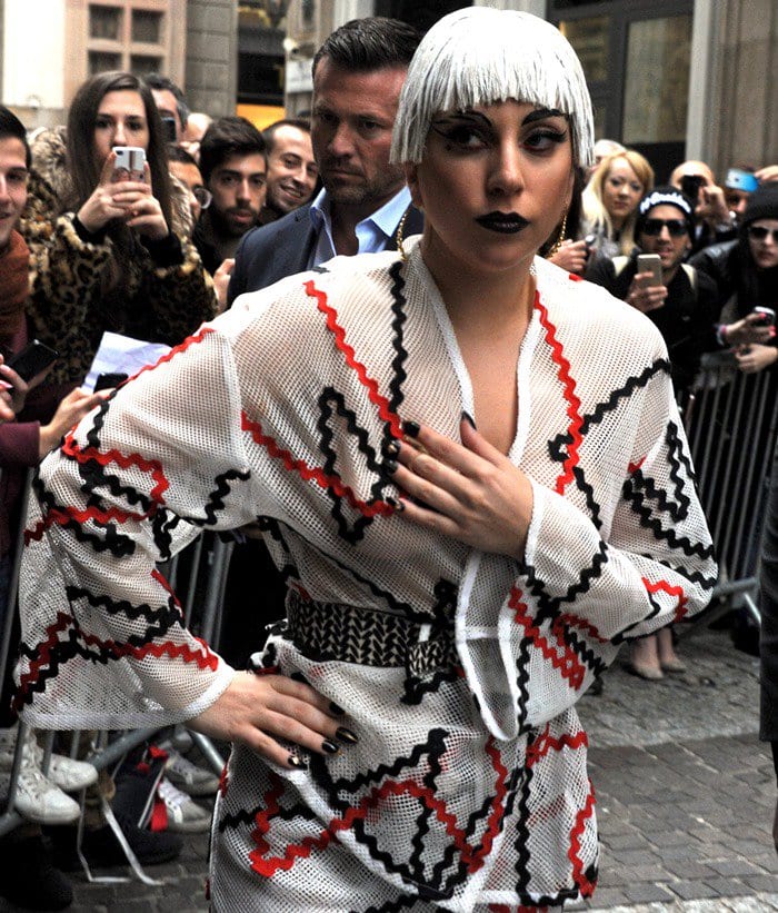 Lady Gaga in an eye-catching top and skirt combo paired with black fishnet tights