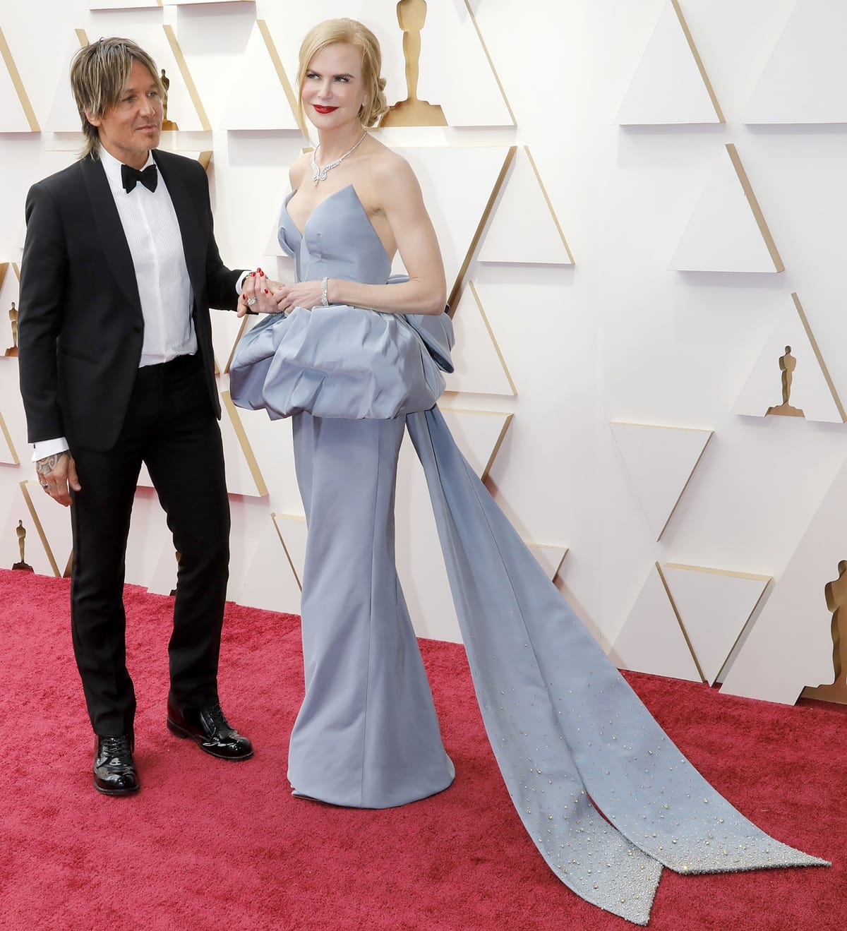 Nicole Kidman in a custom Giorgio Armani Privé light blue silk faille strapless bustier gown and her husband Keith Urban in an Emporio Armani black shawl collar tuxedo at the 2022 Academy Awards