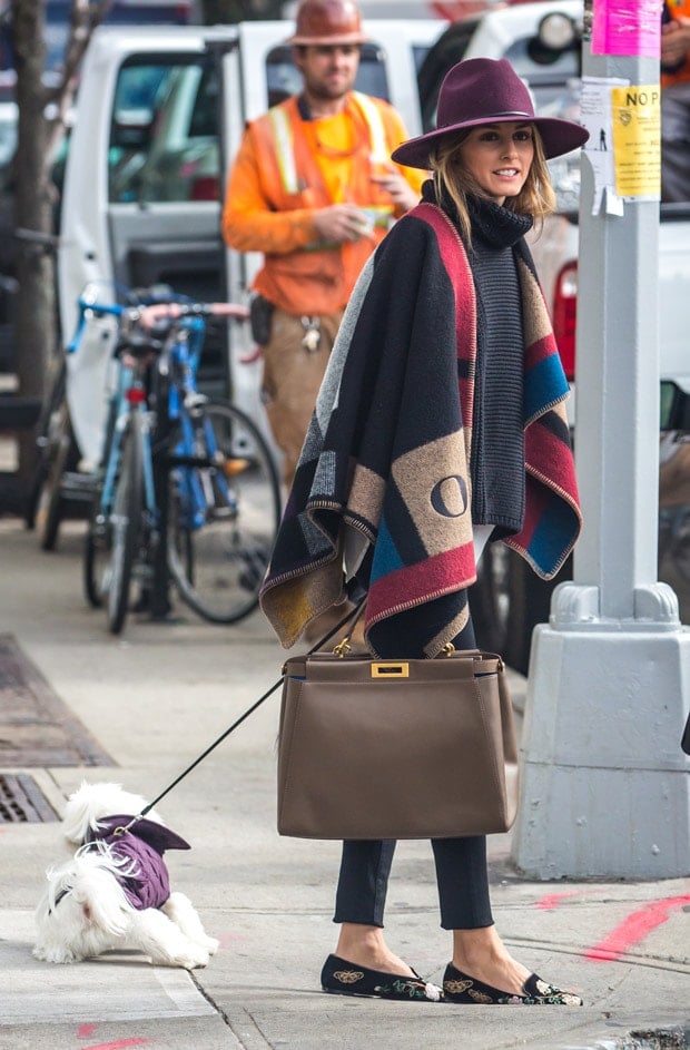 Olivia Palermo looking stylish wearing a hat and a Burberry color block check blanket poncho, running errands in Brooklyn on October 21, 2014