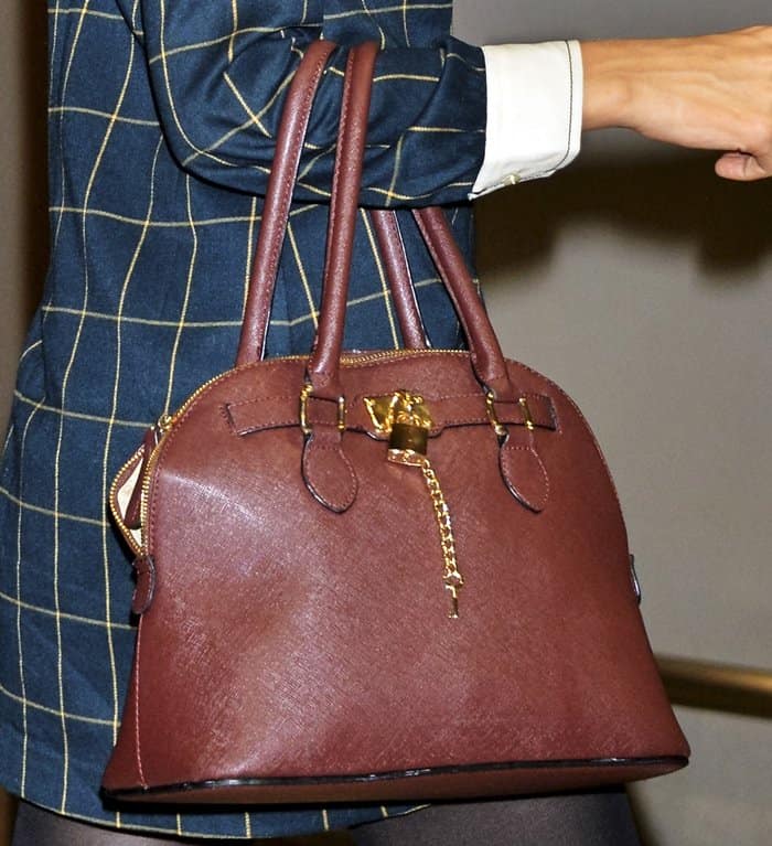 Taylor Swift carries the Bordeaux Aldo "Frattapolesine" handbag, a structured, budget-friendly purse with luxe gold hardware and designer-inspired details