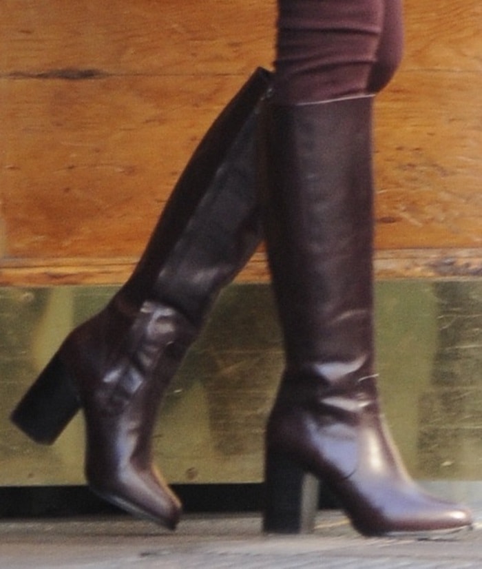 Taylor Swift steps out in sleek burgundy knee-high boots from & Other Stories, featuring a block heel and minimalist silhouette perfect for fall styling