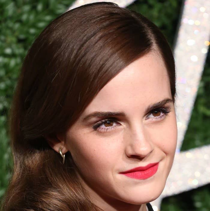 Emma Watson's elegant look with a bold red lip and sleek side-swept waves