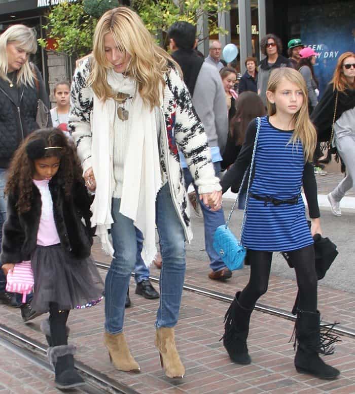 Heidi Klum steps out in skinny jeans, an oversized scarf, and heeled cowboy ankle boots