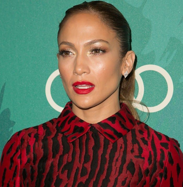 Jennifer Lopez styled her red and black leopard-print dress with sleek, pulled-back hair, bold red lipstick, shimmering gold eye makeup, and diamond stud earrings